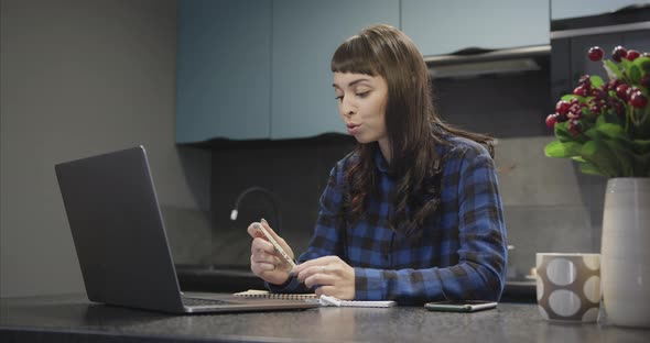 Portrait of a Young Girl in Headphones Talking in Front of a Laptop Screen alt