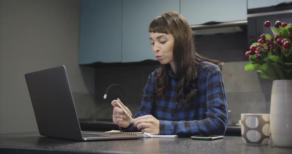 Portrait of a Young Girl in Headphones Talking in Front of a Laptop Screen