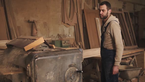 The Master in Overalls Inserts a Large Rail Into the Grinding Machine Pulls It Out alt