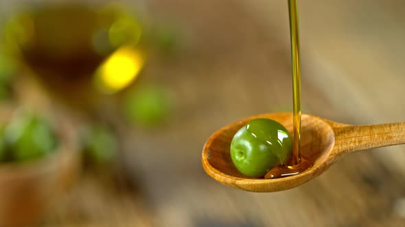 Super Slow Motion Shot of Pouring Fresh Olive Oil on Olive at 1000 Fps. alt