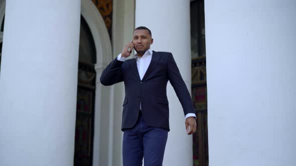Handsome African American Businessman Walking Down Stairs Talking on the Phone alt