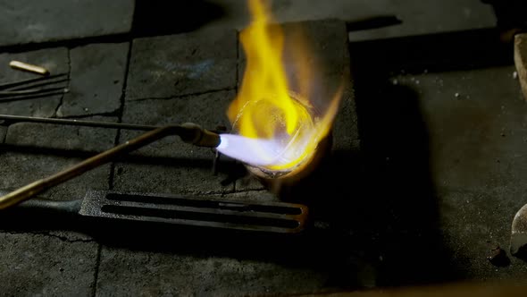 Welding torch is being used to melt jewellery in workshop 4k alt