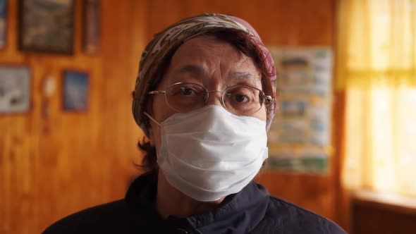 Elderly Woman in a Medicine Protection Mask at Home . Quarantine Coronavirus Covid-19 for Old People