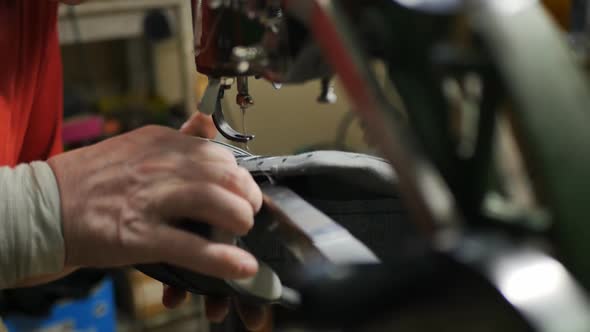Shoemaker Starts Sewing a New Seam on a Sneaker with an Old Typewriter alt