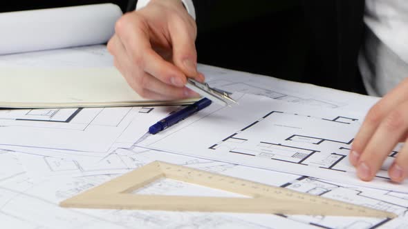 Businessman with a Compass and Ruler Makes Measurements for the Drawing. Close Up alt