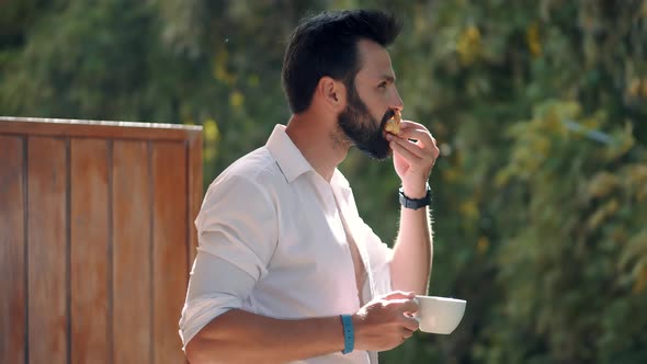 Man In Sunglasses Relaxing In Resort And Having Breakfast. Businessman Drinking Coffee. Caribbean. alt