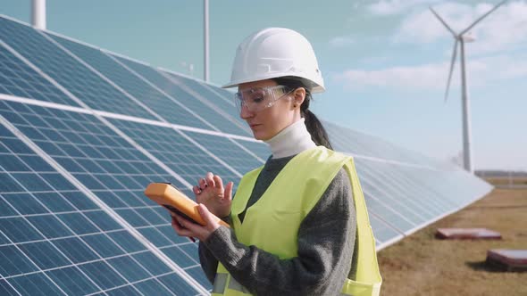 Close Up of Ecological Engineer Checking Information on a Solar Panel Field