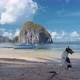 El Nido. A Dog on the Beach in Front of Local Boat on Shore with Pinagbuyutan Island in Background - VideoHive Item for Sale