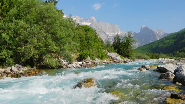 Rapid Mountain River Water with Majestic Rocky Mountains at Background alt