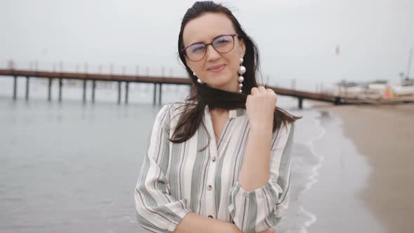 Portrait of Woman in Glasses Talking on the Beach and Enjoy the Walk alt