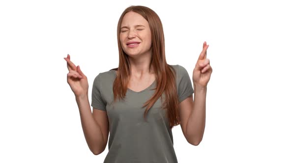 Portrait of Dreaming Redhead Woman 20s Keeping Fingers Crossed in Praying and Begging God Please alt