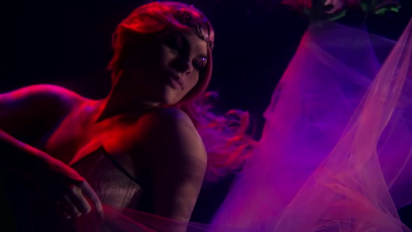 Portrait of a Woman with Long Red Hair, Wearing a Tiara and a Corset. She Floats in the Dark Water alt