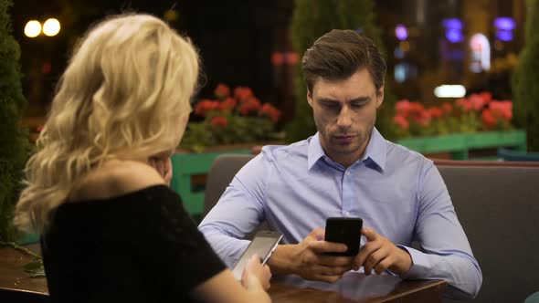 Married Couple Paying No Attention to Each Other Scrolling Pages on Smartphones alt