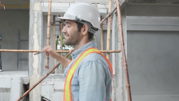Portrait of Asian man engineer at building site looking at camera