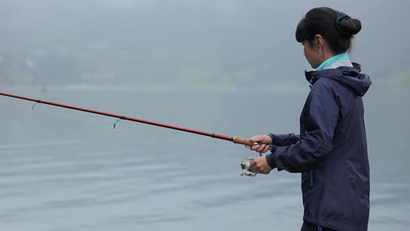 Woman Fishing on Fishing Rod Spinning in Norway alt