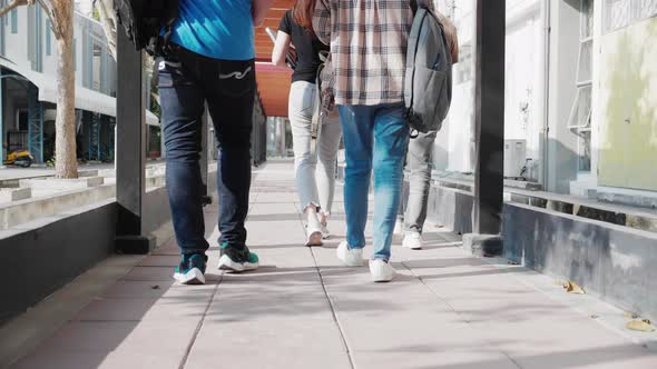 close-up of leg of Group of diverse attractive casual students walking and talking on walkway
