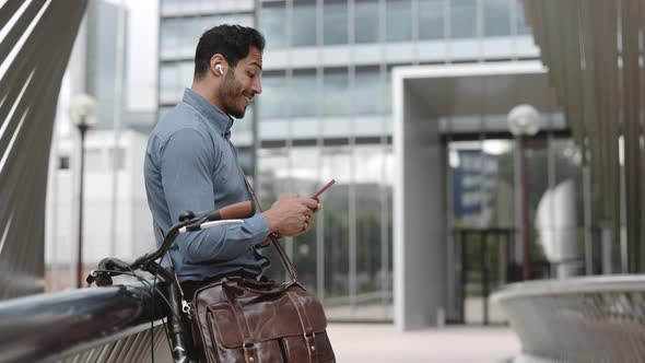 Smiling Businessman Reading Good News on Mobile Outdoors
