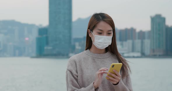 Woman wear face mask and use of mobile phone