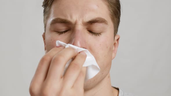 Close Up Portrait of Young Man Wiping His Bleeding Nose with Tissue Slow Motion alt