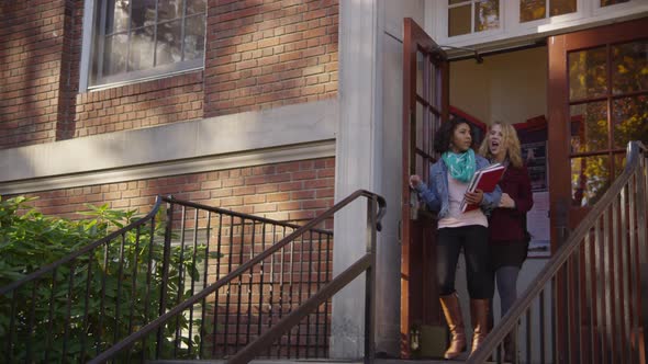 Two college students on campus walking down stairs