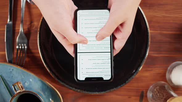 Woman Using Online Menu in Cafe Top View Scanning Qr Code with Smartphone in Restaurant alt