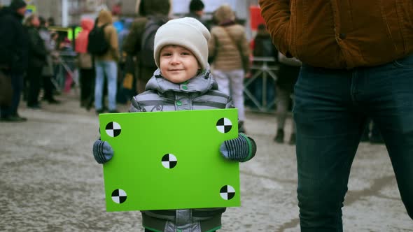 Smiling Child with Chromakey Placard at Political Strike