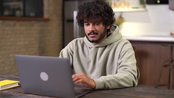 Happy and Optimistic Indian Man in Casual Wear Using Laptop in Modern Flat