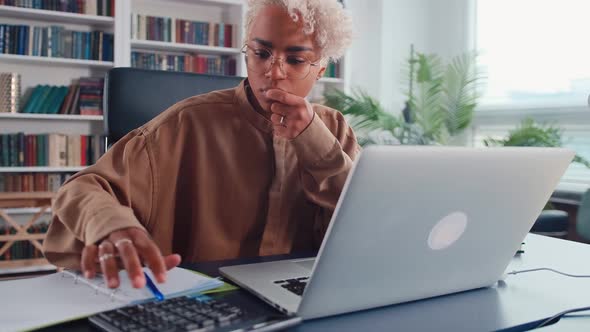 Young African American Woman Counts on Calculator and Gets Very Upset alt