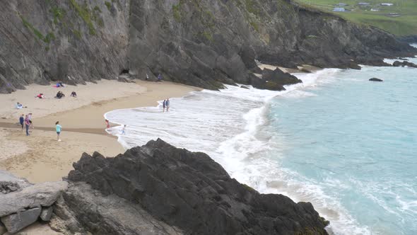 Tourists Enjoying At Coumeenoole Beach, Republic of Ireland - wide shot alt