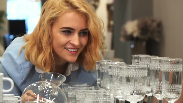 The Girl Is Choosing New Wineglasses for Home