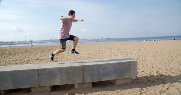 a Young Man is Engaged in Parkour on a Sandy Beach Near the Sea or Ocean a Healthy Lifestyle alt