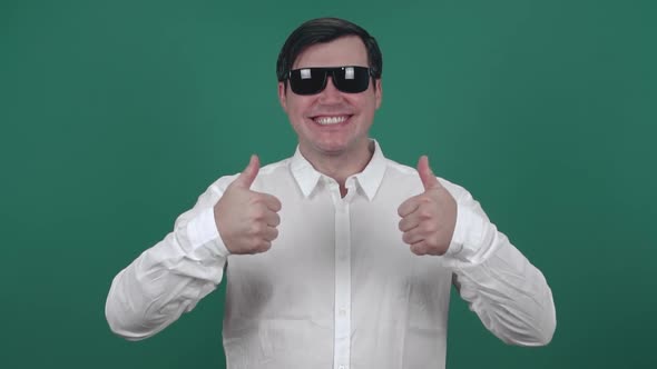 Male in sunglasses smiles and shows class with his hands. Slow motion