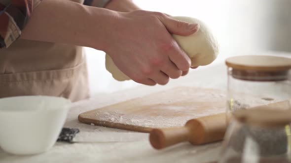 Kneading Fresh Cream Colored Dough To Make Homemade French Bread. alt