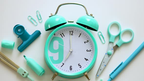 Blue alarm clock with school supplies