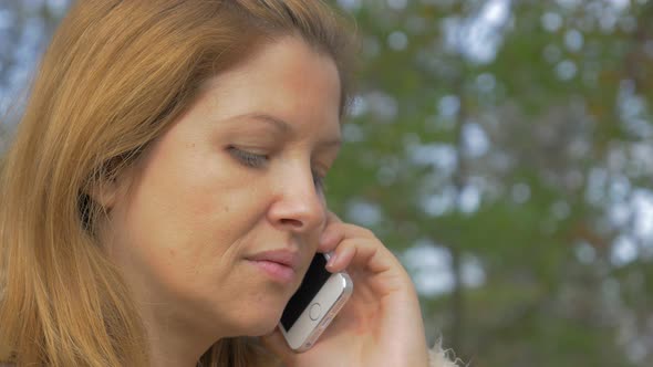 Girl in natural environment having conversation on mobile phone 4K 3840X2160 UHD video - Talking on  alt