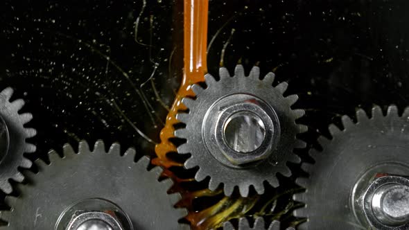 Super Slow Motion Shot of Gear Mechanism and Oil on Dark Background at 1000 Fps alt