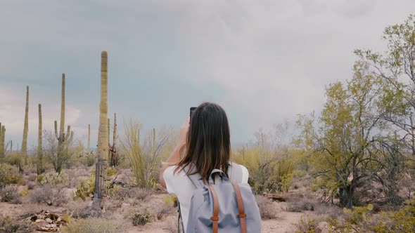 Slow Motion Back View Young Happy Traveler Woman Taking Smartphone Photo of Stormy Sky at Desert