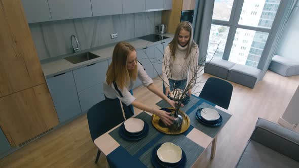 Female Designers Decorating Dinner Table in Luxurious Apartment 