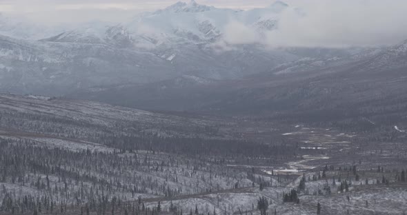 Aerial helicopter flyover above Alaskan bay, past forests and inlets, beaches, drone footage alt