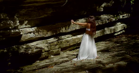 Alluring Female Belly Dancer Is Moving in Forest on Rocks, Back View alt