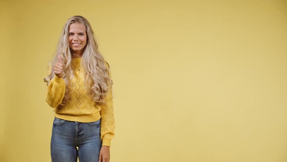 Young Cheerful Model with Long Curly Locks Giving a Thumbs Up alt