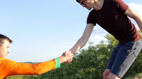 A tourist lends a helping hand while climbing the mountain. alt