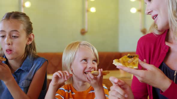 Mother and kids having pizza in restaurant 4k alt