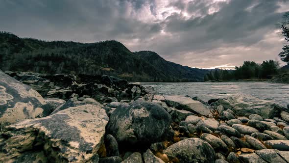 Time Lapse Shot of a River Near Mountain Forest. Huge Rocks and Fast Clouds Movenings. Horizontal alt