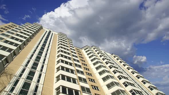 Multi-storey building under construction (new residential complex) against the moving clouds