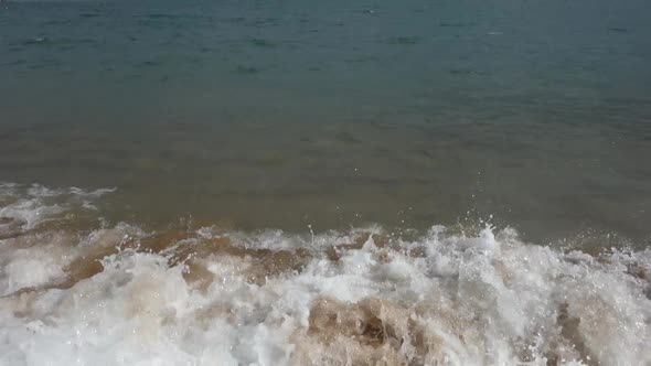 waves crashing on beach sand, slow motion alt