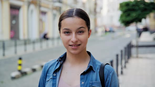 Headshot Portrait of Positive Teenage Young Female Looking at Camera alt