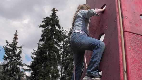 Blonde Junior Schoolgirl with Plait Climbs Up Wooden Wall alt