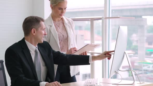 Two Business People Talk Project Strategy at Office alt