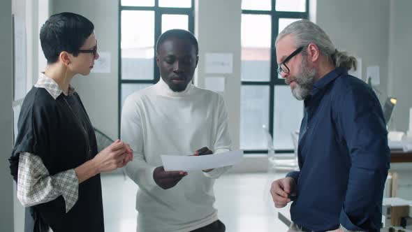 Diverse Multiage Business Team Discussing Business Paper in Office alt